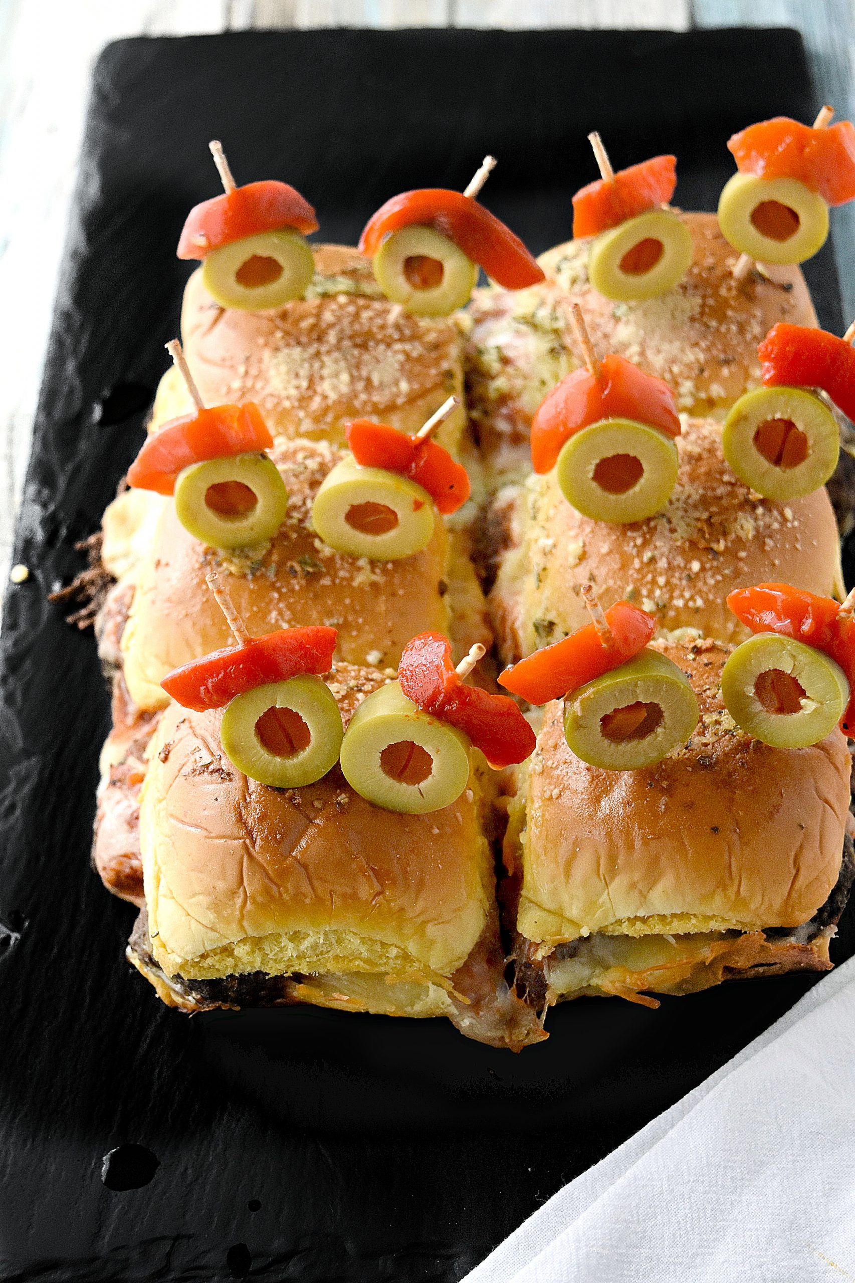 Mini Monster Meatball Sliders are not only fun to make, but fun to eat! Packed with meatballs, cheese, and sauce, these sliders are on the table in no time. #HalloweenTreatsWeek