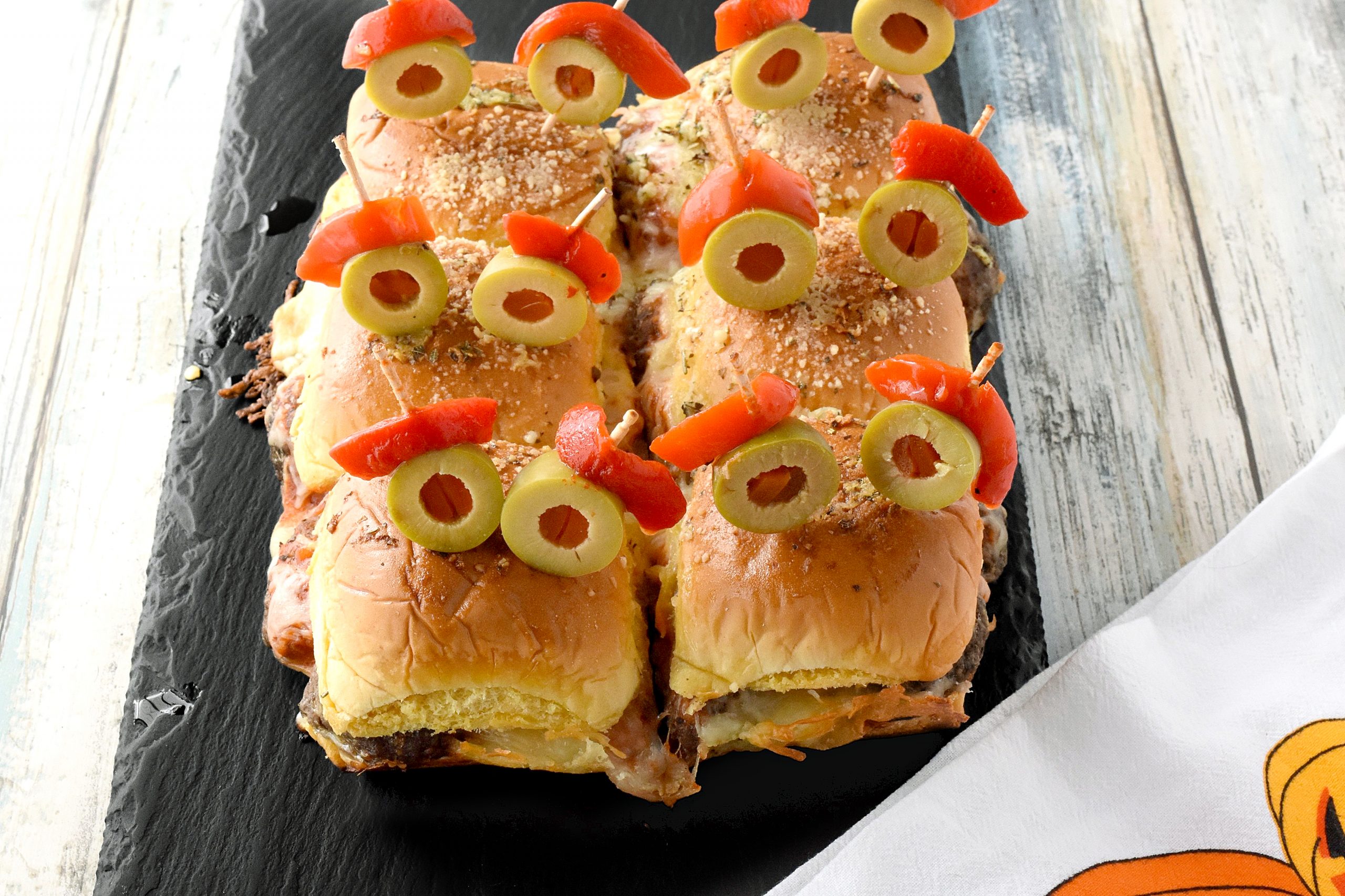 Mini Monster Meatball Sliders are not only fun to make, but fun to eat! Packed with meatballs, cheese, and sauce, these sliders are on the table in no time. #HalloweenTreatsWeek