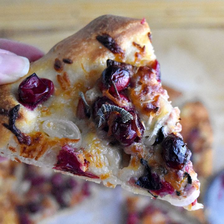 Cranberry and Prosciutto Pizza is cheesy and packed with roasted cranberries, fresh sage, prosciutto, and shallots. With a pre-made pizza dough, it’s a simple and simply delicious meal. #CranberryWeek