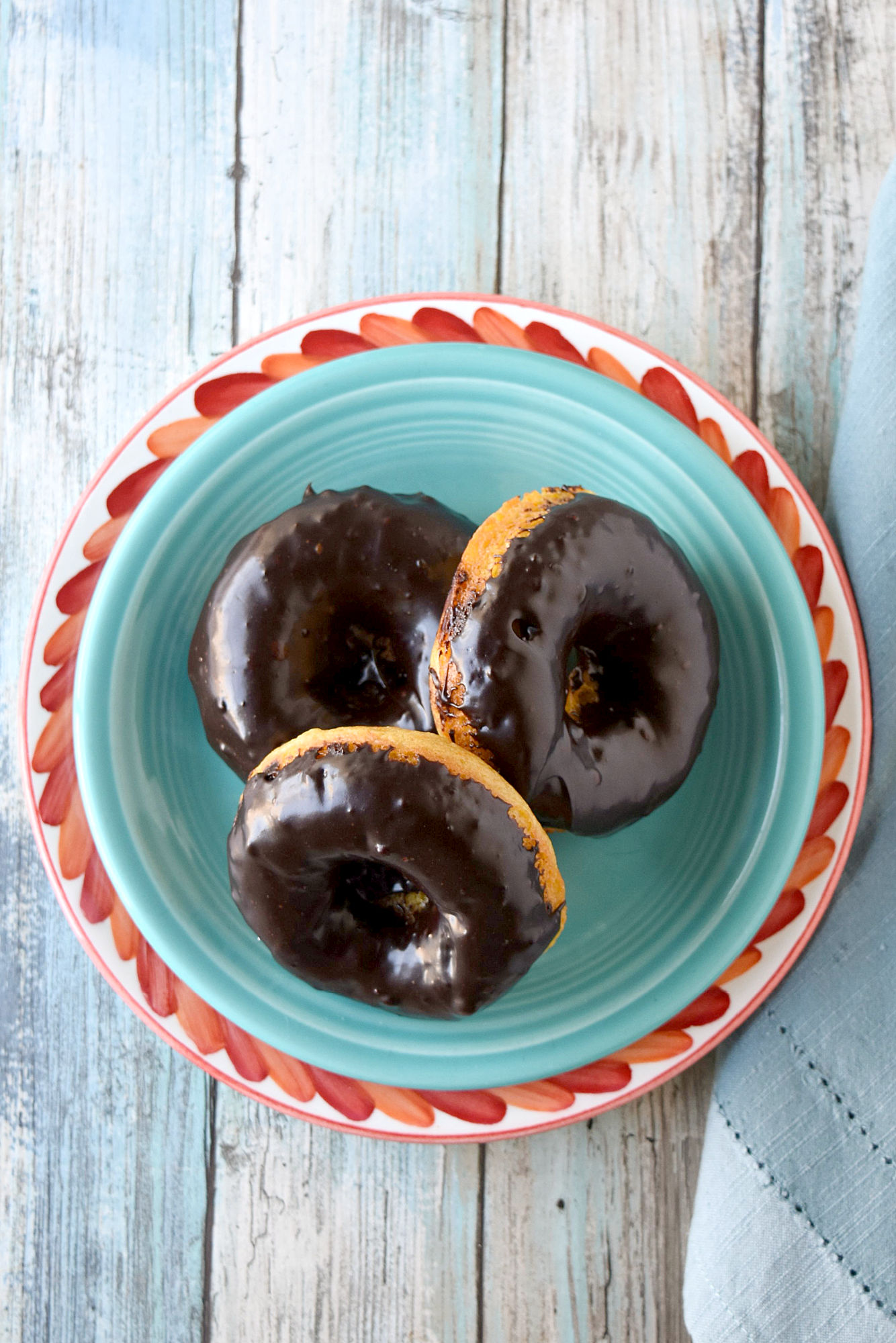 Mandarin Orange Donuts with Ganache Glaze are packed with mandarin orange flavor in a tender baked donut wrapper.  The chocolate scented ganache glaze is an added bonus. #SpringSweetsWeek