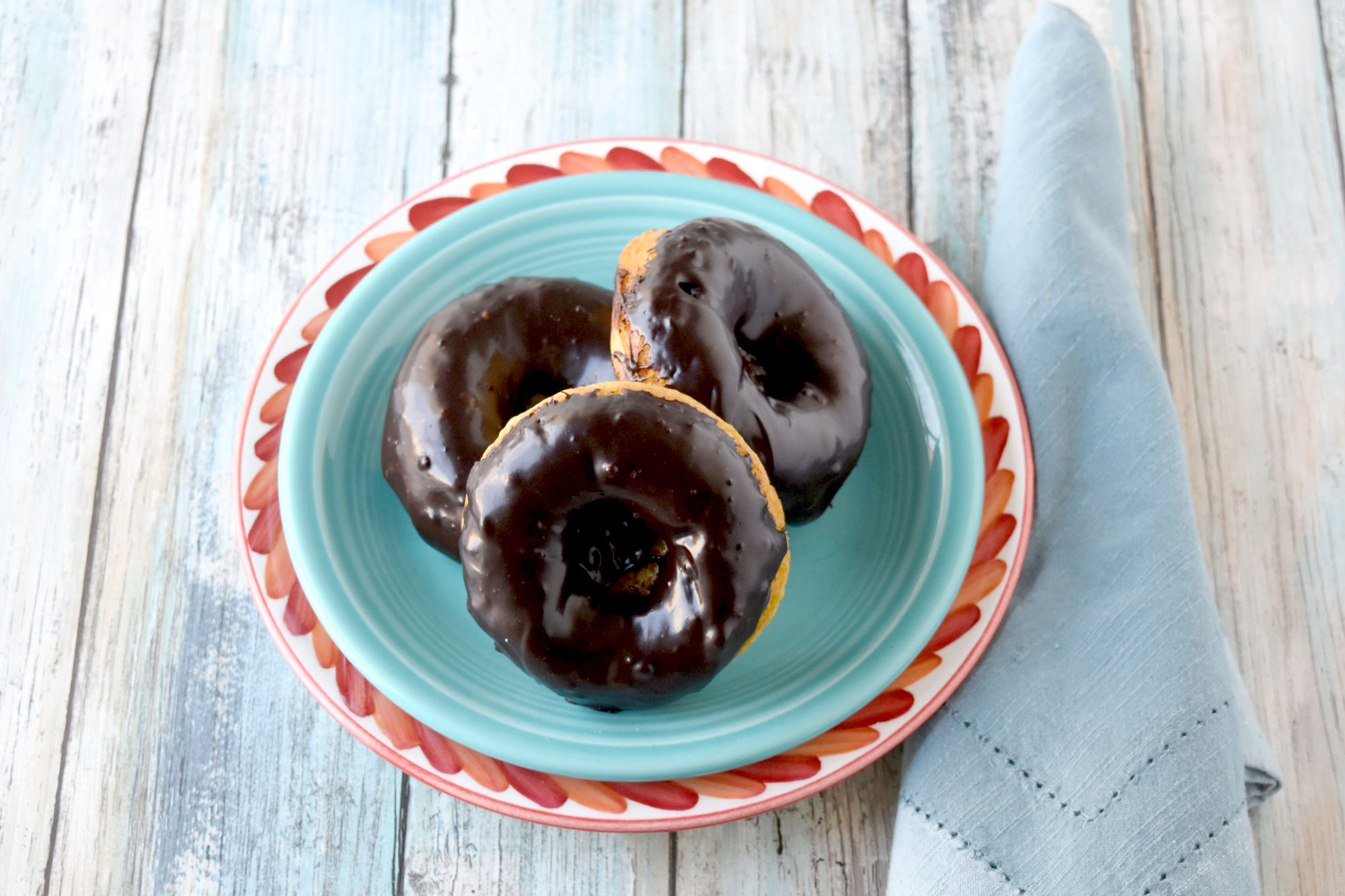 Mandarin Orange Donuts with Ganache Glaze are packed with mandarin orange flavor in a tender baked donut wrapper.  The chocolate scented ganache glaze is an added bonus. #SpringSweetsWeek