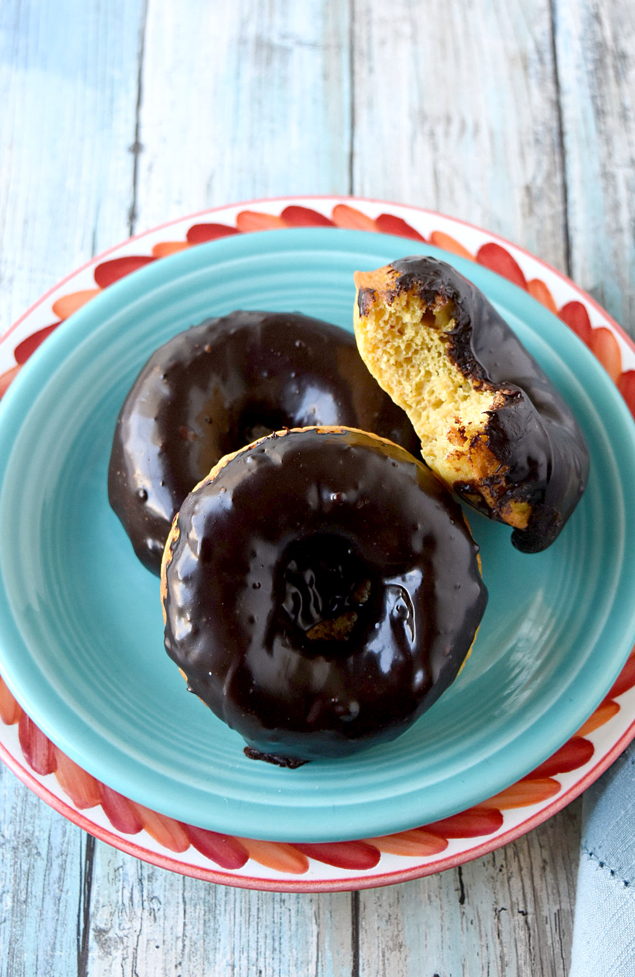 Mandarin Orange Donuts with Ganache Glaze are packed with mandarin orange flavor in a tender baked donut wrapper.  The chocolate scented ganache glaze is an added bonus. #SpringSweetsWeek