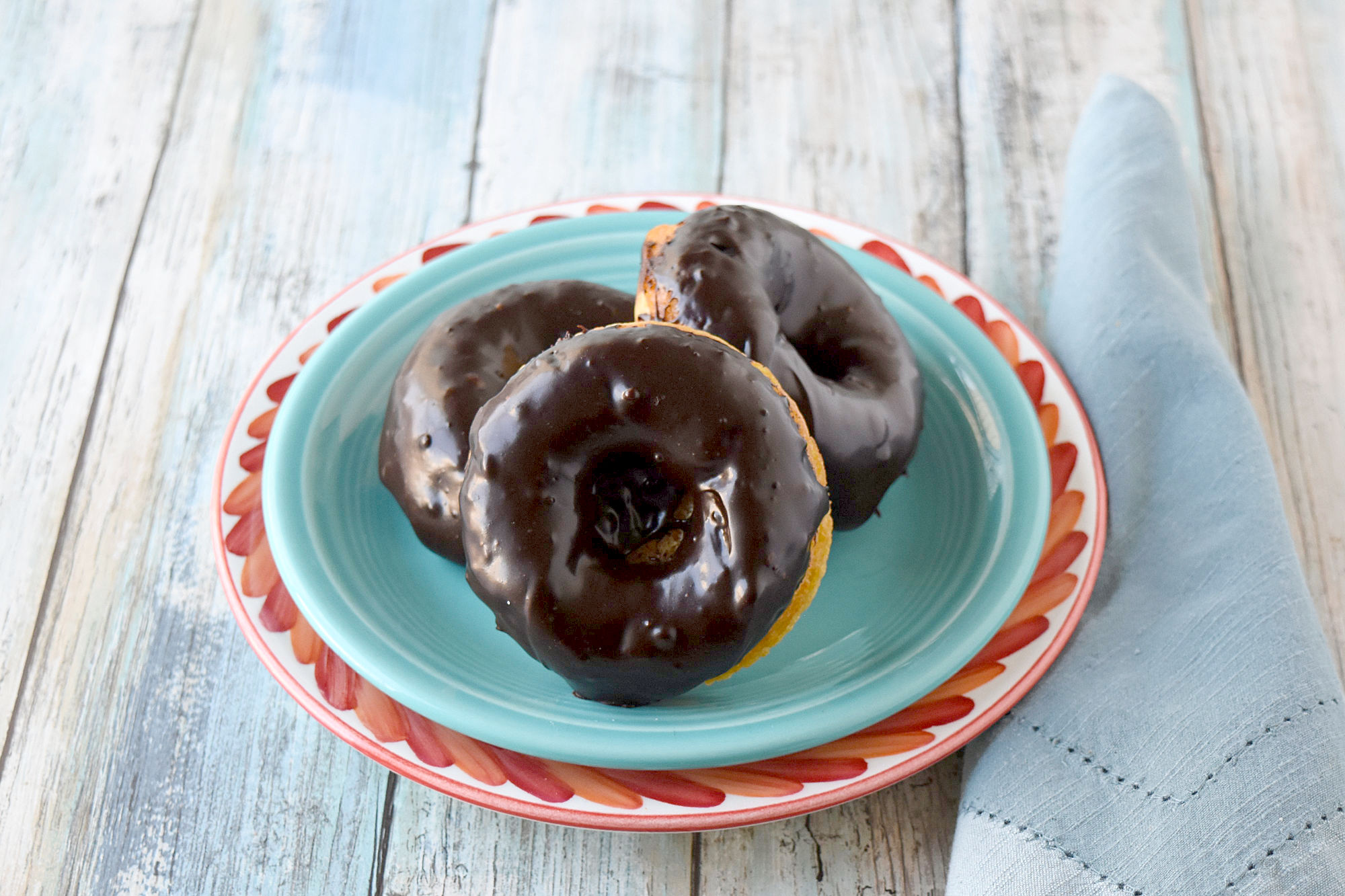 Mandarin Orange Donuts with Ganache Glaze are packed with mandarin orange flavor in a tender baked donut wrapper.  The chocolate scented ganache glaze is an added bonus. #SpringSweetsWeek