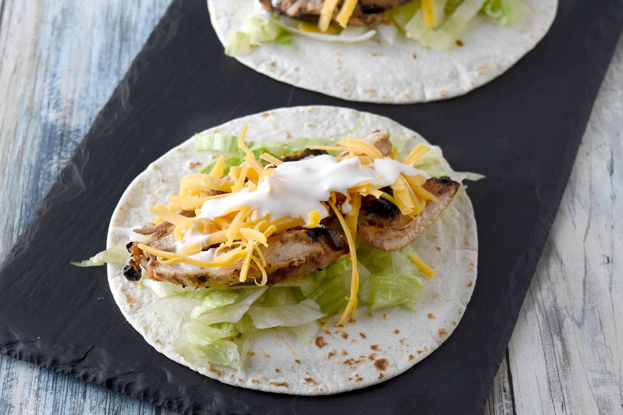 Cuban Marinated Chicken Tacos are marinated with orange and lime juice, cumin, garlic, and minced onion. Boneless, skinless chicken thighs means they grill up quick for any night of the week. #BBQWeek