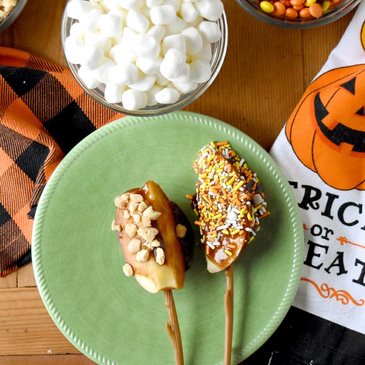 Caramel Apple Board is packed with fun toppings and a delicious peanut butter caramel.  Made with brown sugar, the caramel sauce is simple to make and tastes delicious. #HalloweenTreatsWeek