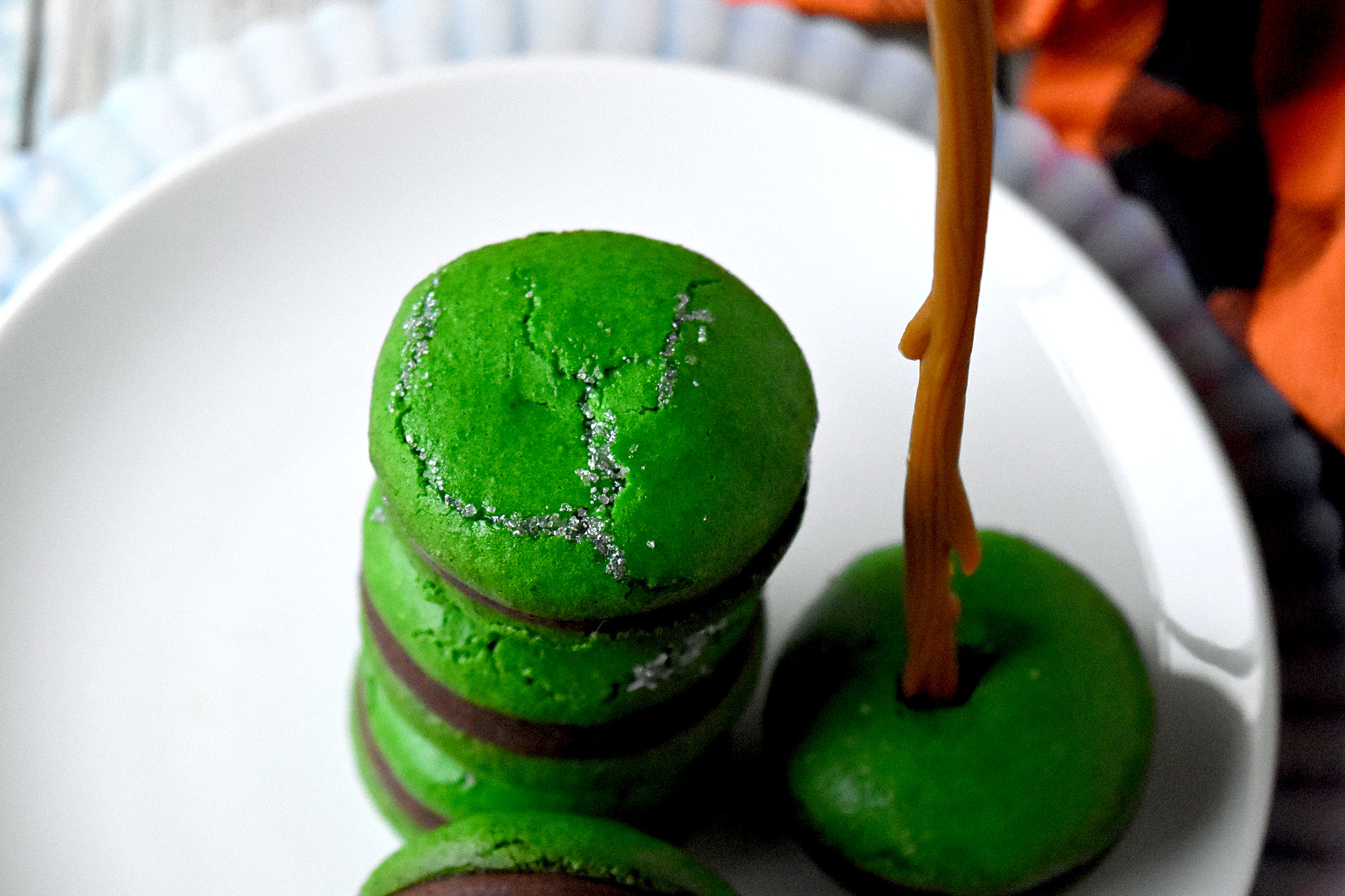 Poisoned Apple Macaron have freeze dried apples in the shells and apple simple syrup in the chocolate filling.  Don't let the color fool you!  They are perfectly delicious and totally not poisoned! #HalloweenTreatsWeek