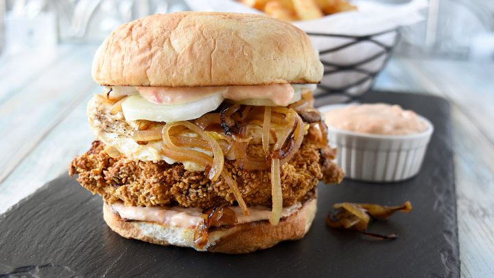 Crispy Nasi Lemak Chicken Sandwich has so much flavor! It has a coconut lime marinated chicken thigh coated in corn cereal topped with caramelized onions, crispy cucumber, a fried egg, and delicious sambal fry sauce. #SeriousFoodieRecipeChallenge #SeriousFoodie #BitesAroundTheWorld