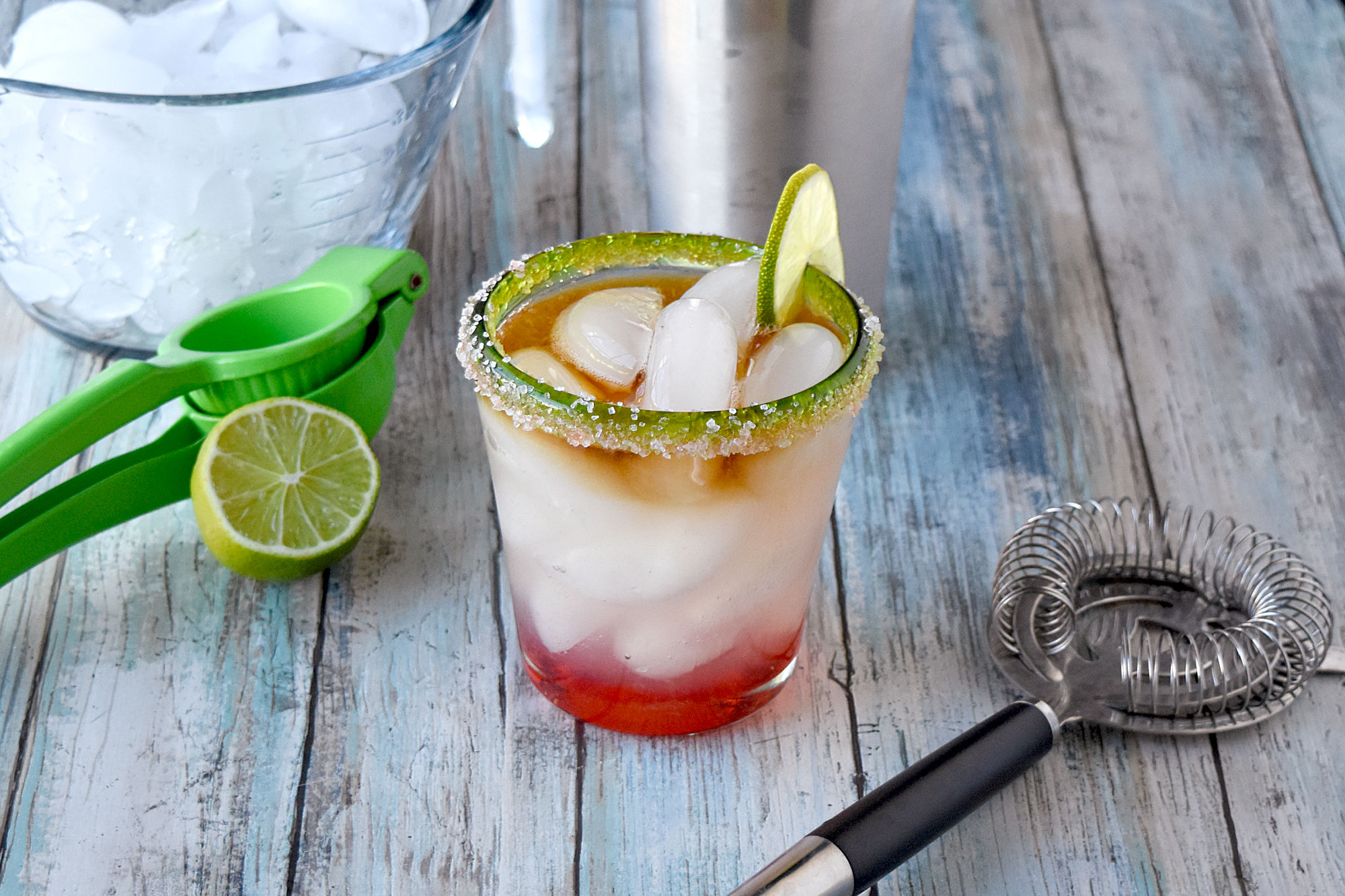 Mai Tai Margarita has the flavors of the tropical Mai Tai and refreshing margarita. Grenadine is in the bottom, the margarita with coconut rum is in the middle, and dark rum floated on top for a deliciously layered drink. #OurFamilyTable