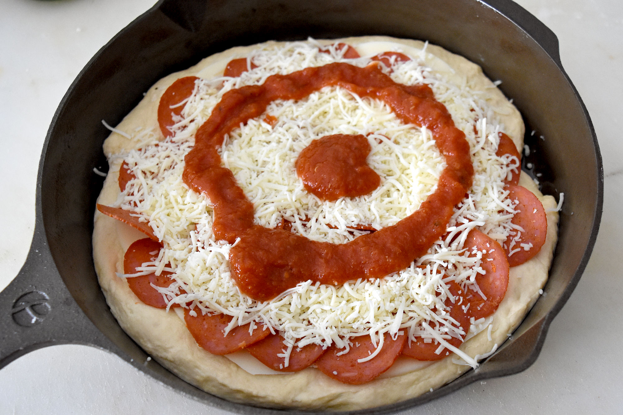 A bullseye of sauce tops this Detroit Style Deep Dish Pizza.