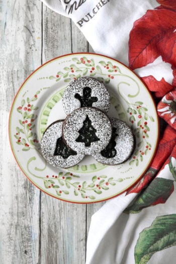 Chocolate Mint Linzer Cookies have a slightly sweet, chocolate shortbread like cookie filled with mint jelly. Yes. Mint jelly. It’s a unique and delicious cookie for the holidays. #ChristmasCookies #linzercookies #mintjelly #chocolatemintcookies #cutoutcookies