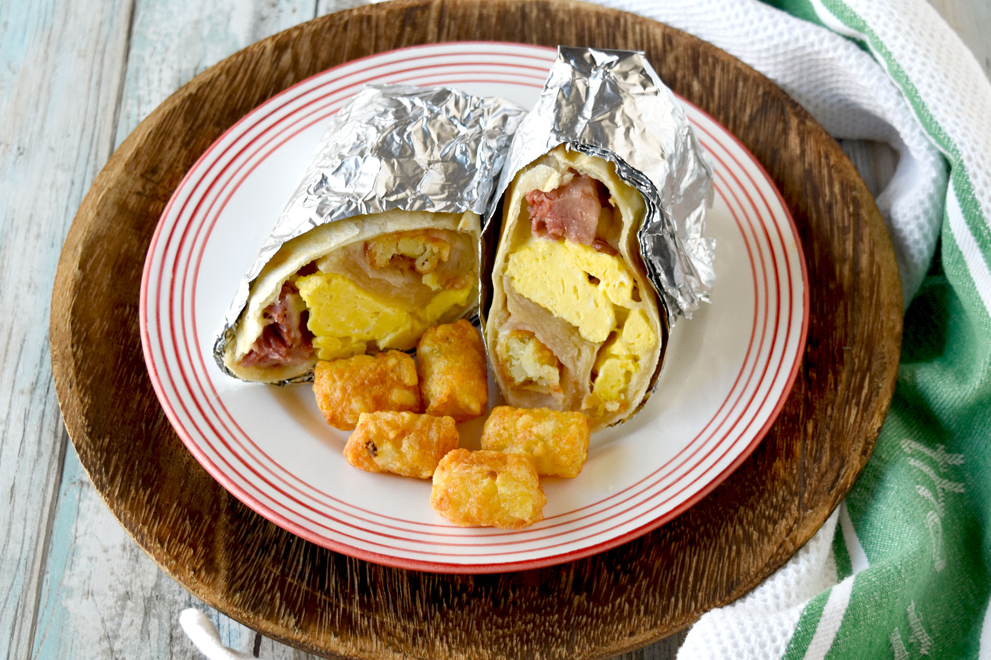 Easy Freezer Breakfast Burritos whip up in no time, are hearty and filling, and you can easily change up the ingredients to match your taste. They’re a perfect grab and go breakfast for work!  #OurFamilyTable #breakfast #brunch #freezermeal #freezerburrito