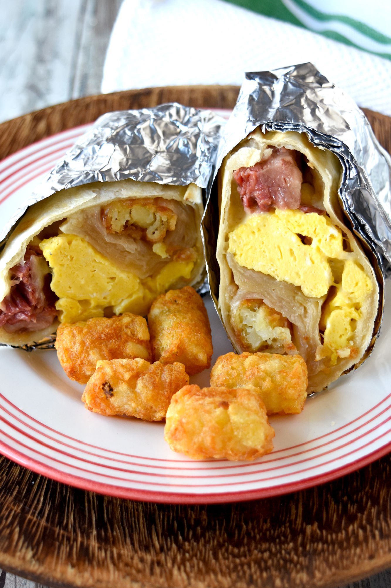 Easy Freezer Breakfast Burritos whip up in no time, are hearty and filling, and you can easily change up the ingredients to match your taste. They’re a perfect grab and go breakfast for work!  #OurFamilyTable #breakfast #brunch #freezermeal #freezerburrito