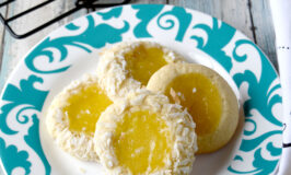 Key Lime Coconut Thumbprints have a sweet tart filling in a deliciously tender thumbprint sugar cookie. The sprinkle of grey sea salt on top is the hidden flavor that rounds out all the flavors in these cookies. #SpringSweetsWeek #Easter #KeyLimes #microwavecurd #cookierecipe