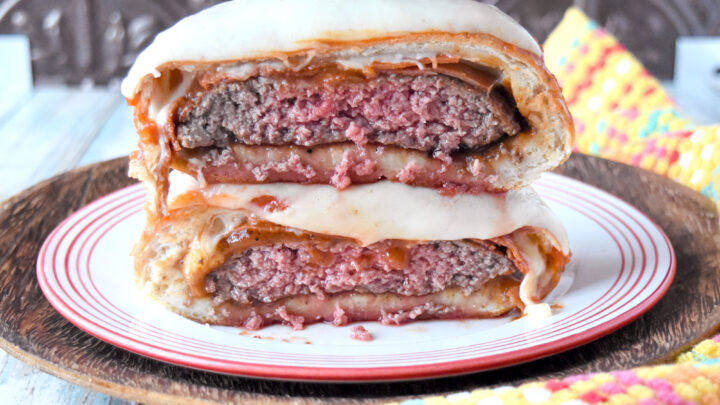 This Pizza Burger Bomb combines a fun dinner roll with a delicious hamburger. A seared burger gets a topping of pizza sauce, pepperoni, and cheese and a wrapping if delicious pizza dough for a bun twist on a burger. #OurFamilyTable #BurgerMonth #pizzaburger #burgerbomb #pizzabomb