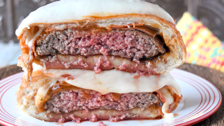 This Pizza Burger Bomb combines a fun dinner roll with a delicious hamburger. A seared burger gets a topping of pizza sauce, pepperoni, and cheese and a wrapping if delicious pizza dough for a bun twist on a burger. #OurFamilyTable #BurgerMonth #pizzaburger #burgerbomb #pizzabomb