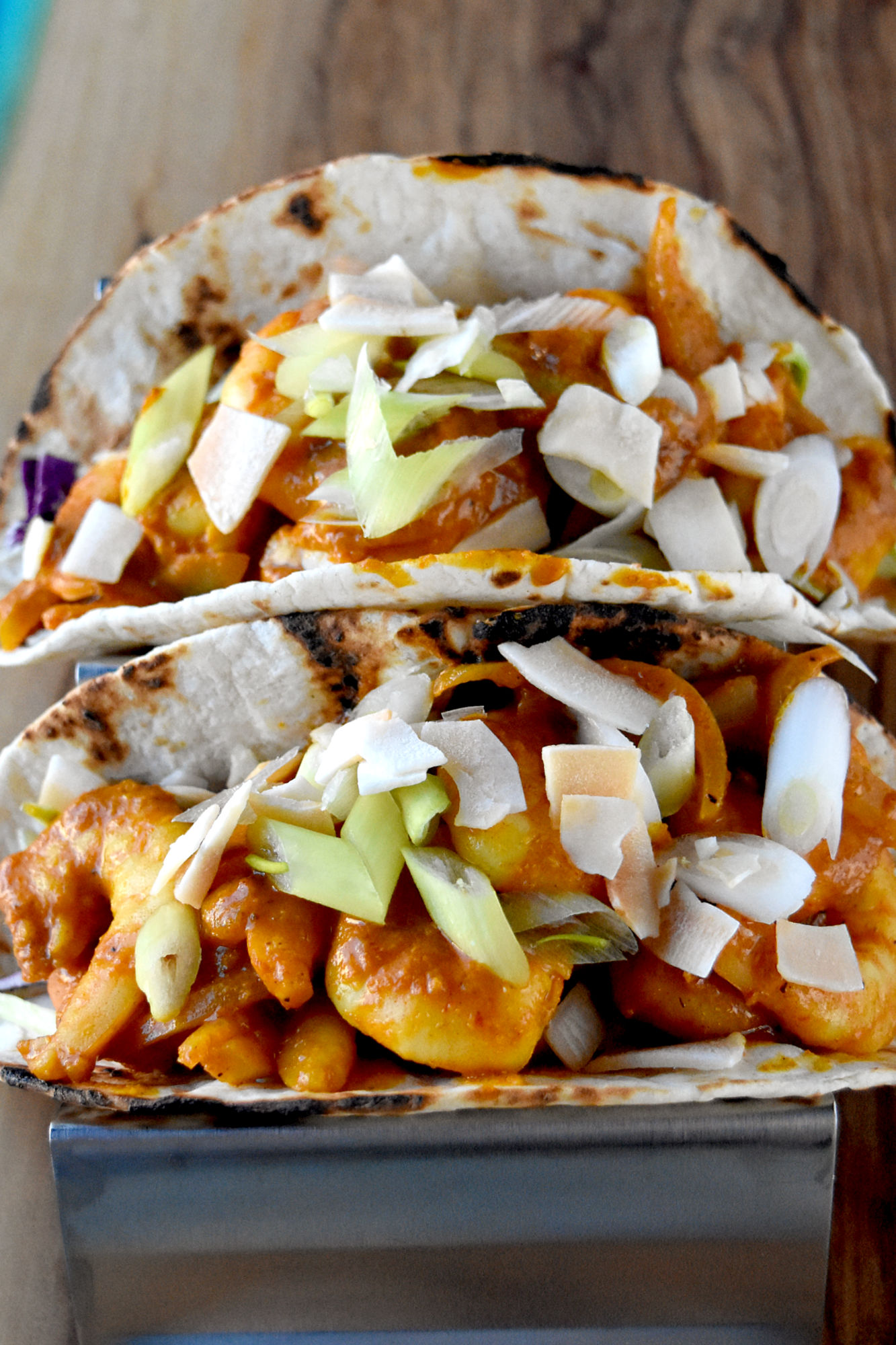 Curry Coconut Shrimp Tacos are succulent, rich, and full of curry flavor. They’re a fun twist on an Asian dish and perfect for #TacoTuesday! #OurFamilyTable #Thaicoconutcurry #coconutcurry #Thaicurry #currytacos #TacoTuesday
