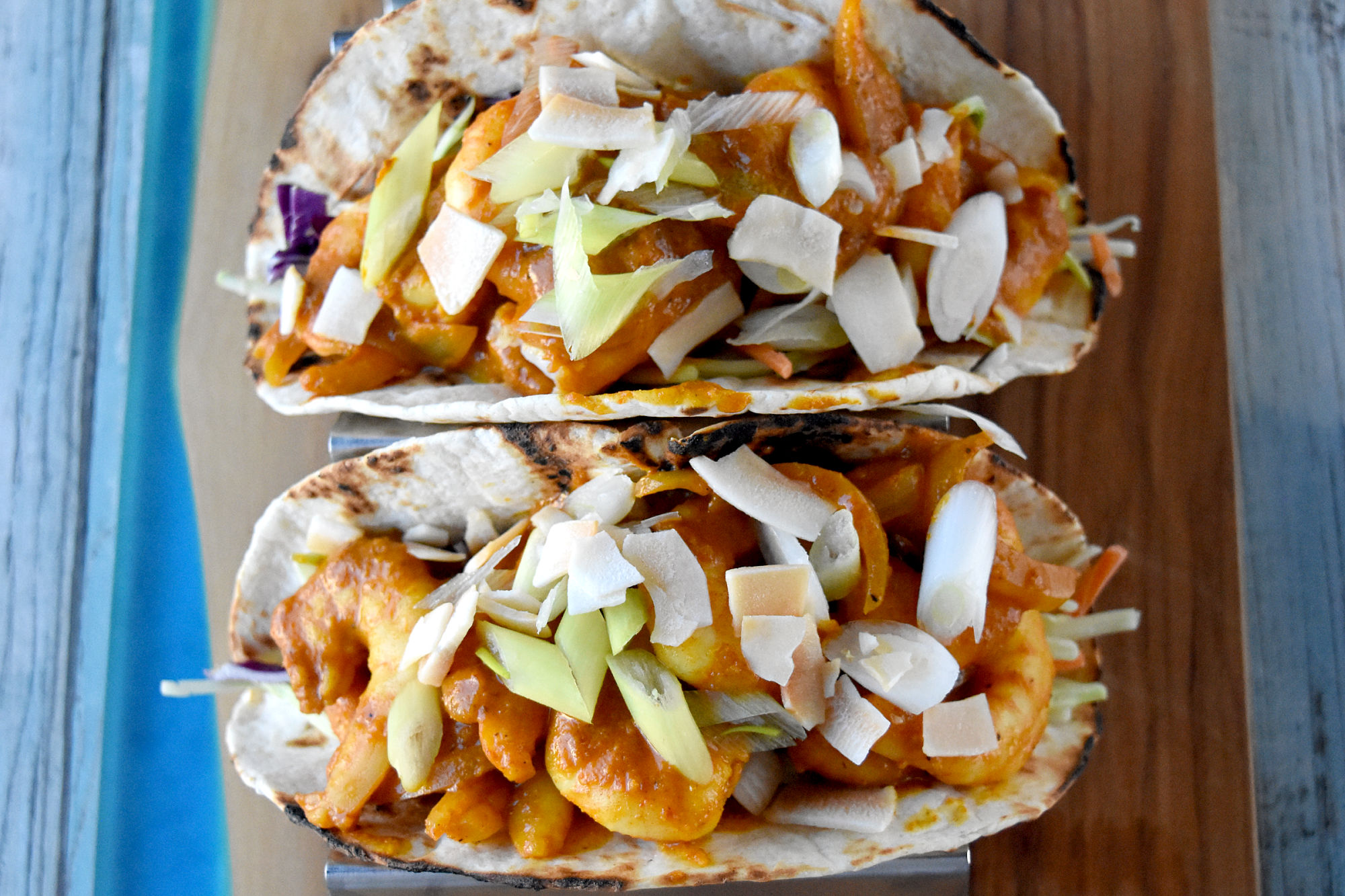 Curry Coconut Shrimp Tacos are succulent, rich, and full of curry flavor. They’re a fun twist on an Asian dish and perfect for #TacoTuesday! #OurFamilyTable #Thaicoconutcurry #coconutcurry #Thaicurry #currytacos #TacoTuesday
