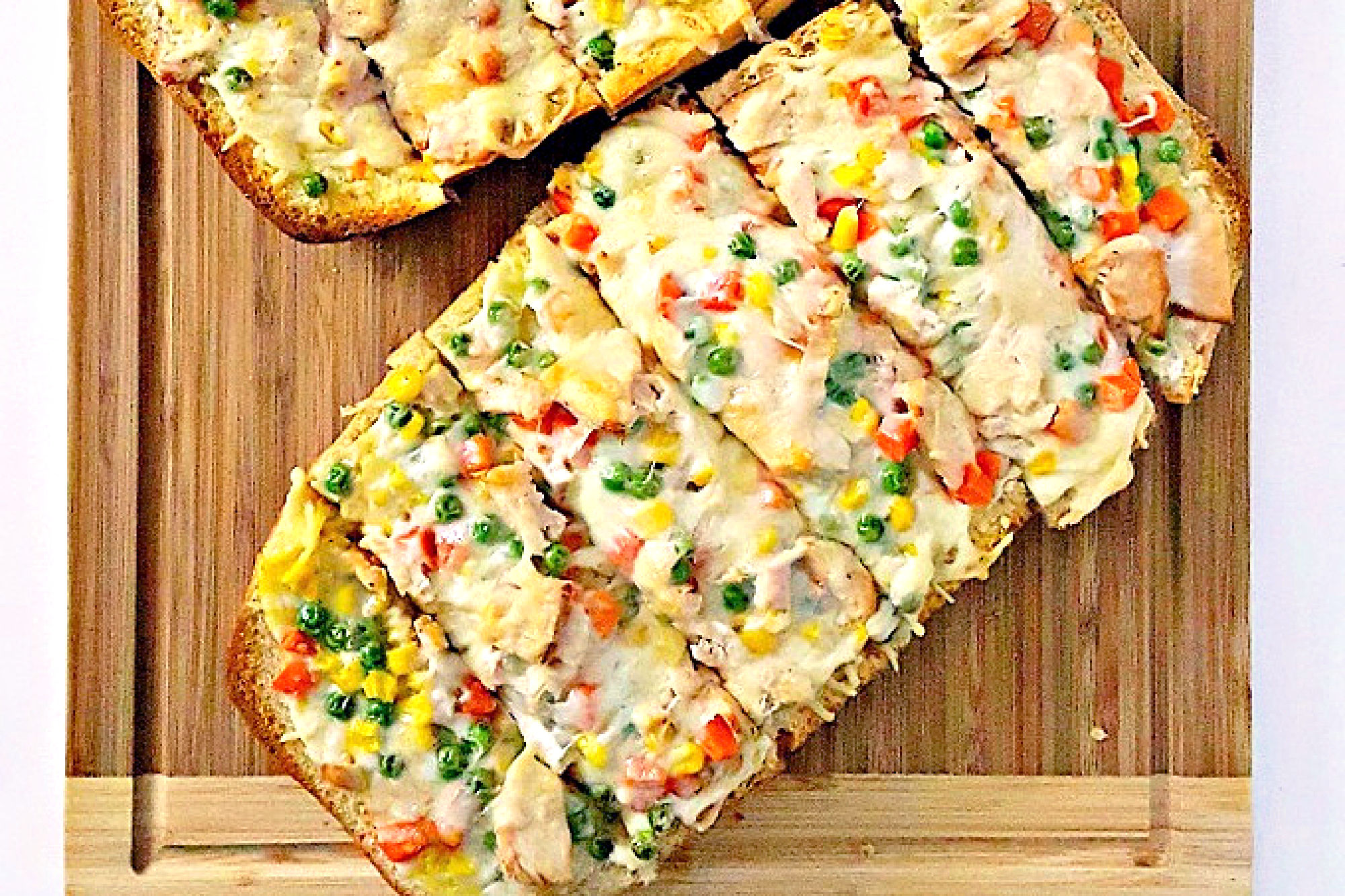 Get ready for a flavor explosion with Chicken Pot Pie French Bread Pizza.  It's the ultimate comfort food mashup. Trust us, one bite and you'll be hooked. #OurFamilyTable #ChickenPotPiePizza #FrenchBreadPizza #EasyDinnerRecipes #HomemadeComfortFood #FamilyDinnerIdeas
