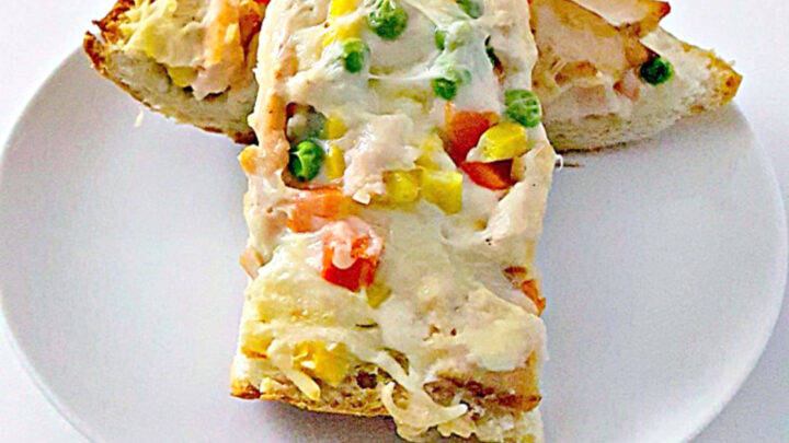 Get ready for a flavor explosion with Chicken Pot Pie French Bread Pizza.  It's the ultimate comfort food mashup. Trust us, one bite and you'll be hooked. #OurFamilyTable #ChickenPotPiePizza #FrenchBreadPizza #EasyDinnerRecipes #HomemadeComfortFood #FamilyDinnerIdeas