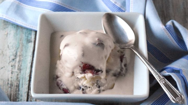 Elevate your ice cream game with this delicious cherry pie mascarpone ice cream. Trust us, it's worth the brain freeze. July is Ice Cream Month. And July 9th is Ice Cream Social Day. That’s why I’m sharing this cherry pie mascarpone ice cream. It was either this or beer and pretzel ice cream. I just couldn’t find a single micro brew to use for the ice cream. So, I went with option two in this cherry ice cream. I made a pistachio mascarpone ice cream a little while ago. It was rich, creamy, and oh so delicious. And the mascarpone helped keep the ice cream from freezing rock hard. I could somewhat easily scoop it out the next day. Since I had success then, I thought I’d try adding mascarpone to this ice cream recipe, too. Where does ice cream come from? The story of ice cream’s invention is woven through centuries and across continents. Like most recipes, its true origins are hidden in legend and innovation. Ancient Chinese emperors are said to have enjoyed frozen treats made from milk and rice. They chilled this treat with snow brought down from the mountains. The Persian empire made sharbat crafted from fruit, honey, and snow to cool the summer heat. Sounds like sorbet to me! The Renaissance Italians refined the idea further. They created gelato by blending milk, cream, sugar, and flavorings together. By the 17th century, ice cream had reached France and then England. As with most cultural culinary creations, it became a favorite among royals and aristocrats. Over time, each culture added its own flair. And over time ice cream evolved from rare luxury to beloved everyday indulgence. There are more flavors than I can count. This is a reflection of how versatile and customizable this treat truly is. Custard vs. Non-Custard Ice Cream At the heart of every ice cream recipe lies a decision: custard-based or not? There are some purists who swear that only custard-based ice cream is TRUE ice cream. It is known as the French-style ice cream. This type of ice cream consists of a custard base made with egg yolks, sugar, and cream. This results in a rich, velvety texture. Non-custard, or Philadelphia-style, skips the eggs in favor of simplicity and a lighter taste. The base in this ice cream omits the eggs and cooking time completely. It saves time, but can make for a harder scoop on the second day as there’s little fat to keep crystals from forming. Ice Cream vs. Sorbet vs. Sherbet: What’s the Difference? In the world of frozen desserts, these are sometimes used interchangeably, but each offers a distinct experience. Ice cream has a diary base at the very least. And can have a custard base with the addition of eggs. Sorbet has no dairy at all. It relies on fruit and sugar or simple syrup making for a vibrant fruit treat. Sherbet is a combination of the two. It adds a little dairy to the fruit and sugar. What is Mascarpone? Mascarpone is a fresh, silky cheese beloved for its subtle sweetness and creamy texture. It originated in from Lombardy, Italy. It is best known for being part of tiramisu. But this versatile cheese lends a depth to both sweet and savory dishes. Some use in cheesecake and some fold it into pasta. But when folded into ice cream, it brings a an exquisite creaminess that elevates every bite. Tips for Keeping Your Ice Cream from Freezing Rock Solid Homemade ice cream has a tendency to harden in the freezer, but you can keep your scoops soft and creamy with a few key strategies. I combined sugar and honey in this recipe. Honey doesn’t freeze solid. It just thickens thus making it a good way to keep your ice cream being rock solid. Another ingredient that doesn’t freeze is alcohol. Just a little goes a long way. A tablespoon of alcohol lowers the freezing point which prevents your cherry ice cream from freezing solid. Some swear by parchment on top of the ice cream, but that hasn’t necessarily worked for me. The final trick I have not used yet. I forgot to buy some for this recipe. Xantham gum or guar gum. Both gums are stabilizers for ice cream. They improve the texture and prevent crystals from forming, which causes ice cream to be rock solid. P6H Guar gum is natural polysaccharide derived from guar beans. It acts as a thickening agent to and create a smoother, creamier ice cream. Xantham gum has similar properties, but it’s a polysaccharide produced by fermenting simple sugars with a specific bacterium. Ingredients to make Cherry Pie Mascarpone Ice Cream Pantry ingredients – sugar, honey, vanilla extract, salt Refrigerator ingredients – eggs, milk, cream, mascarpone cheese, cherries, pie crust Instructions to Make This Cherry Ice Cream Recipe First, we start with making the custard base. Whip the yolks with the sugar and the honey until light and creamy. Stir in the milk, whipping cream, vanilla, and salt. Pour the mixture into a medium saucepan. Cook the custard on medium heat and stir every 3 to 5 minutes to keep the eggs from curdling. Coat the back of a spoon with the custard. Drag your finger down the back of the spoon. If the custard doesn’t fill in that line then it’s ready. P7V Strain the mixture through a fine mesh strainer to catch and bits of cooked egg. Let the custard cool in the fridge. Or prepare a larger bowl with ice to cool it down faster. When it’s cool enough pour the custard in your ice cream maker. Follow the instructions for your ice cream maker to mix the ice cream. While the custard is cooling, cook the pie crust at 450 for 7 to 10 minutes or until golden brown. When the ice cream is finished mixing, stir in the chopped cherries. Break the pie crust up into pieces and stir those into the ice cream. Spoon the ice cream into an airtight container. Put plastic wrap on top of the ice cream, like you do with custard, before sealing the container. Chill the ice cream for 2 to 4 hours or overnight. Garnish with cherries and pie crust pieces before serving. P8H What does cherry pie mascarpone ice cream taste like? It is a rich and creamy custard ice cream that is sweet with a lovely flavor of vanilla. The mascarpone makes the ice cream even more creamy and rich. It is a luxuriously smooth ice cream recipe that is irresistible. It’s not your regular store brought ice cream. You can taste the richness that the mascarpone brings to the party. I used frozen sweet cherries for this ice cream. They were not overly sweet and had a hint of tart that goes well with the rich, vanilla flavored custard ice cream base. If you have fresh cherries that are ripe and sweet, feel free to use those. Then there’s the salty and crunchy bits of pie crust that rounds out all the flavors in this ice cream. It’s a fun ice cream that’s also rich and luxurious.