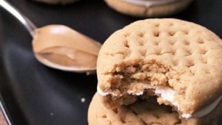 Fluffernutter sandwiches represented in cookie sandwich form with classic peanut butter cookies sandwiched around marshmallow frosting.