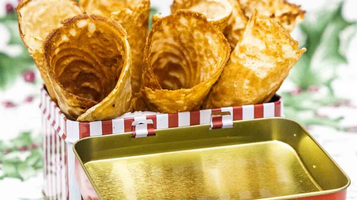 A crisp waffle cookie, rolled into a cone shape and filled with whipped cream, makes a Norwegian Krumkake a fun holiday treat!