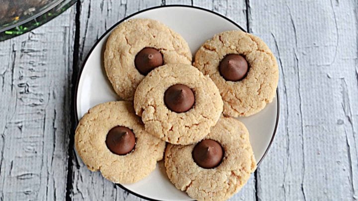 Crisp on the edges, chewy in the middle, these Peanut Butter Blossoms topped with Hershey Kisses are a classic cookie! #cookies #holidays #peanutbutter #chocolate