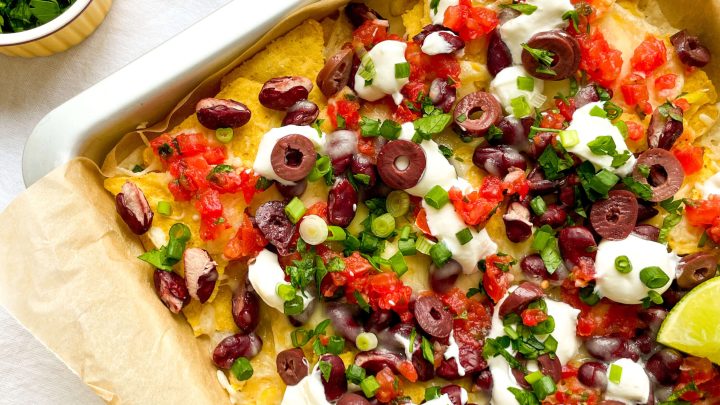 These 7-Layer Sheet Pan Nachos are quick & easy to make and they are so loaded with flavor! Serve as an appetizer, snack, or main dish.