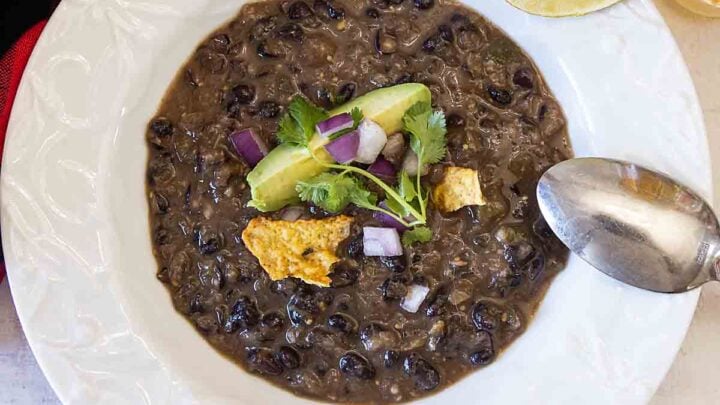 Black Bean Soup is easy, healthy & delicious!  With fun toppings like chips & avocado, even meat lovers will love a gluten free, vegan soup!