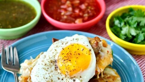 Breakfast nachos loaded with hash browns, sausage, two kinds of cheese, jalapeños, and topped with fried eggs.