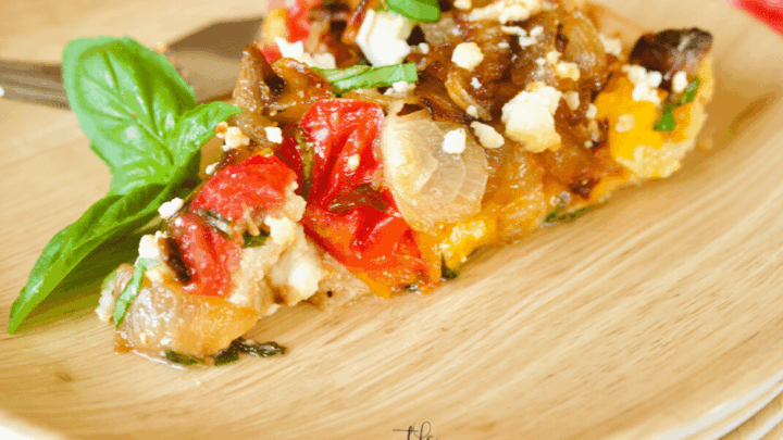 This delicious Heirloom Tomato Pie recipe features caramelized onions, goat cheese, fresh basil and bacon! A hearty appetizer, perfect for summer entertaining, this tomato pie highlights summers freshest produce!