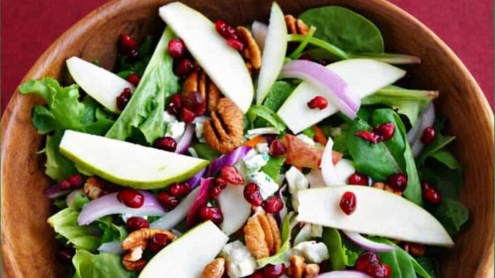 This pear and pecan winter salad layers juicy pears, bold blue cheese, toasted pecans, pops of pomegranate, and a little red onion.