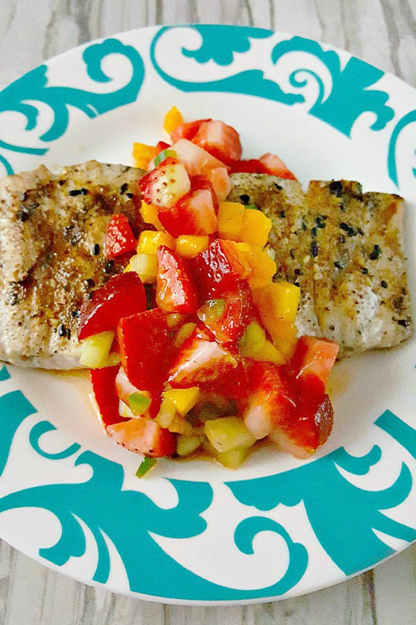 Savor the perfect blend of freshness and flavor with grilled fish topped with strawberry salsa. Dinner al fresco just found its new favorite. #OurFamilyTable #SeafoodLovers #HealthyEating #TastyTreat #GrilledFish #StrawberrySalsa #SummerGrilling #SeafoodLovers #StrawberrySalsa #FishRecipes