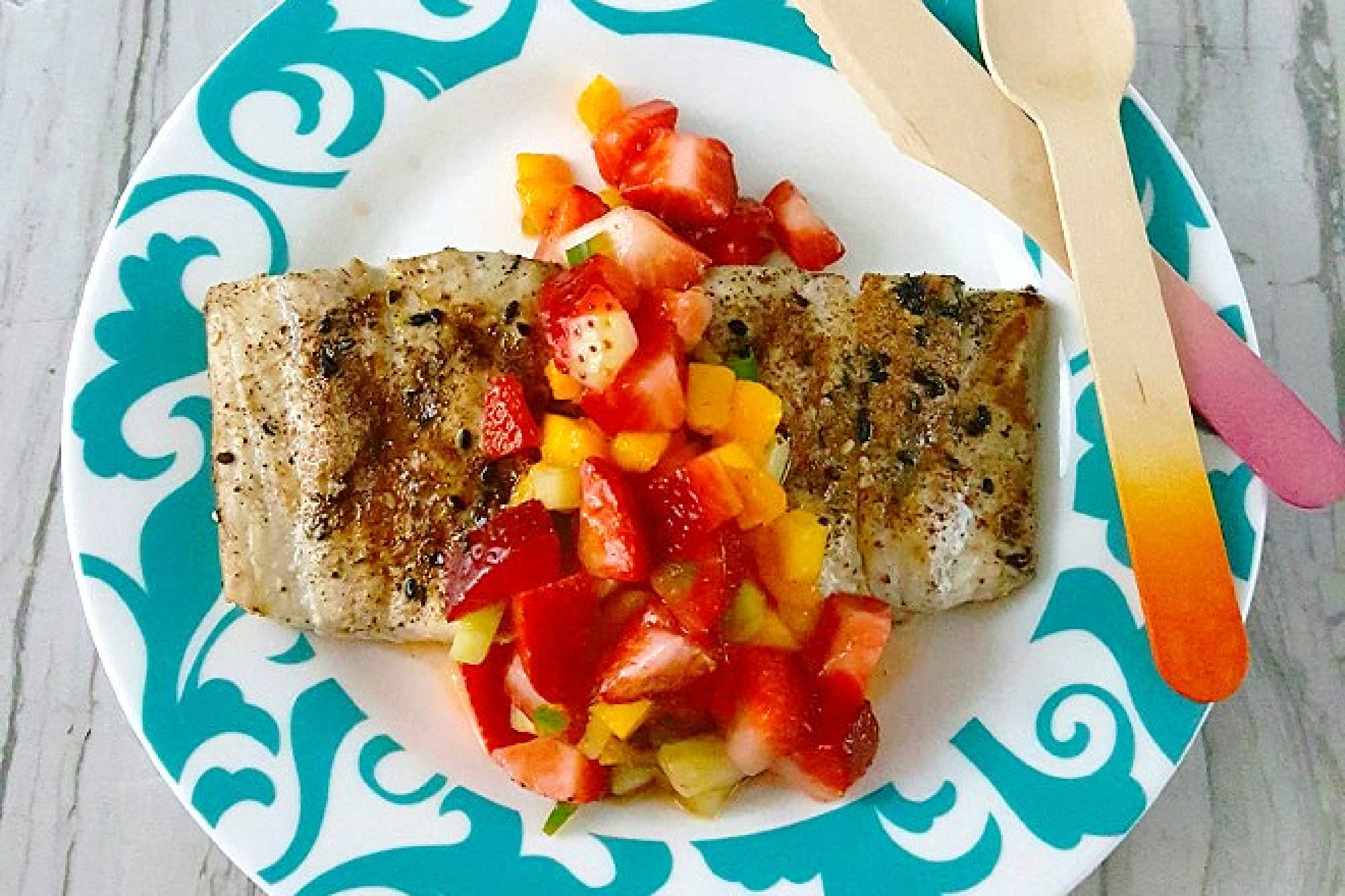 Savor the perfect blend of freshness and flavor with grilled fish topped with strawberry salsa. Dinner al fresco just found its new favorite. #OurFamilyTable #SeafoodLovers #HealthyEating #TastyTreat #GrilledFish #StrawberrySalsa #SummerGrilling #SeafoodLovers #StrawberrySalsa #FishRecipes