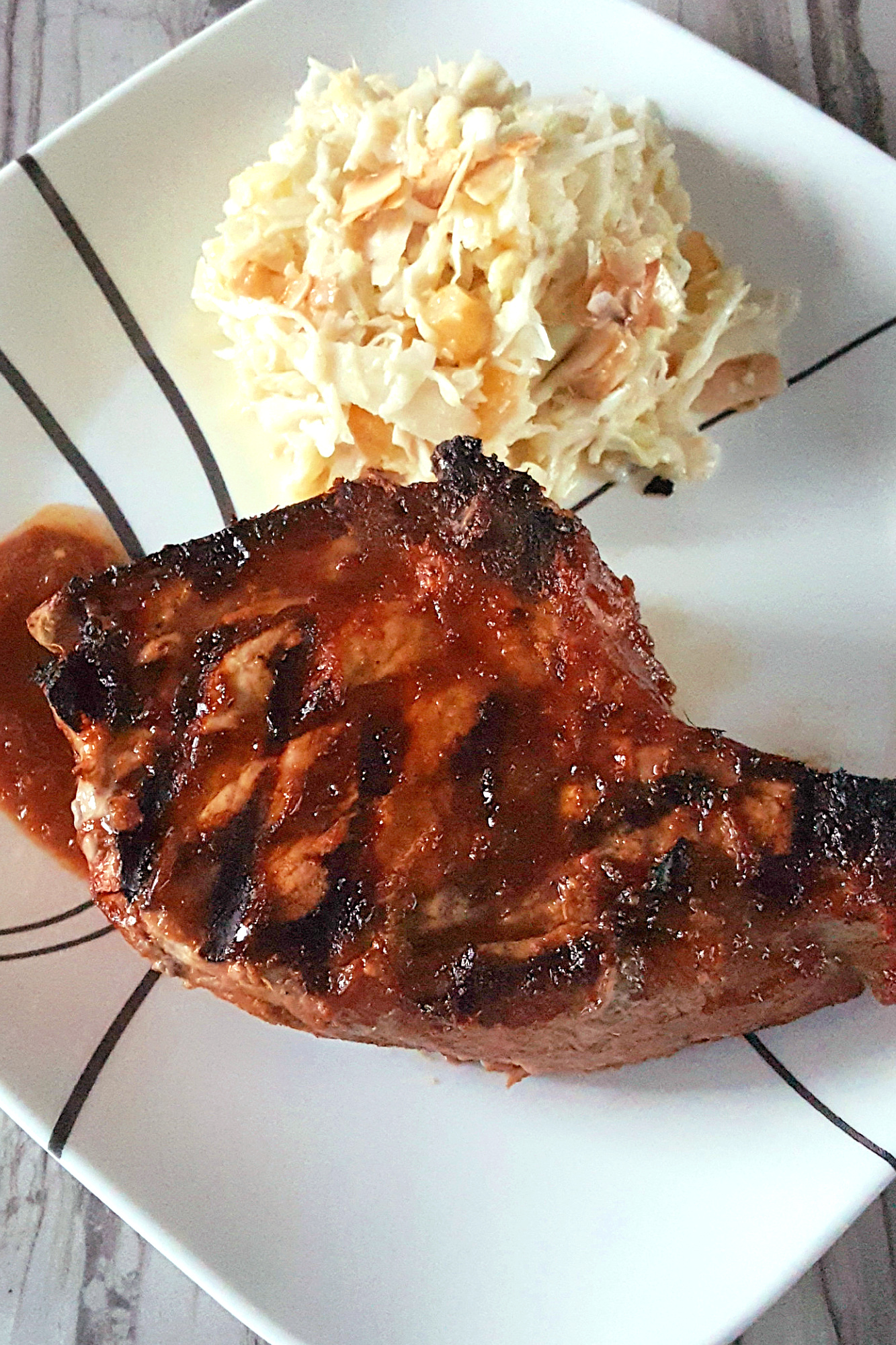 Savor the sweet and smoky harmony of pineapple barbeque chops paired with creamy colada slaw made with coconut chips and macadamia nuts. This dish brings people together and turns any meal into a mini celebration. #bbq #porkchop #pineapplesauce #pineapplebarbecue #PineappleBarbequeChops #ColadaSlaw #BBQlovers #SummerGrilling #TropicalFlavors
