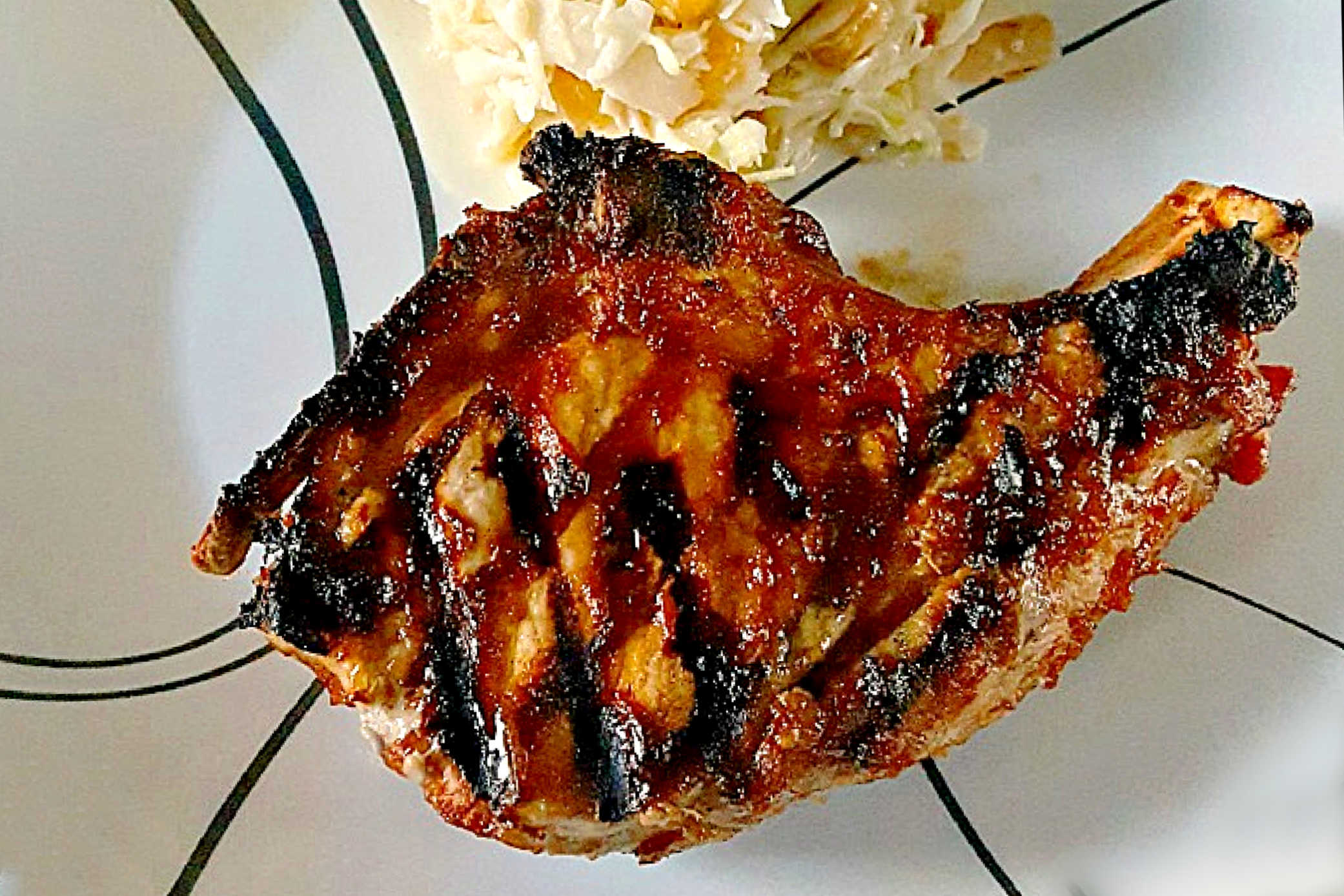 Savor the sweet and smoky harmony of pineapple barbeque chops paired with creamy colada slaw made with coconut chips and macadamia nuts. This dish brings people together and turns any meal into a mini celebration. #bbq #porkchop #pineapplesauce #pineapplebarbecue #PineappleBarbequeChops #ColadaSlaw #BBQlovers #SummerGrilling #TropicalFlavors