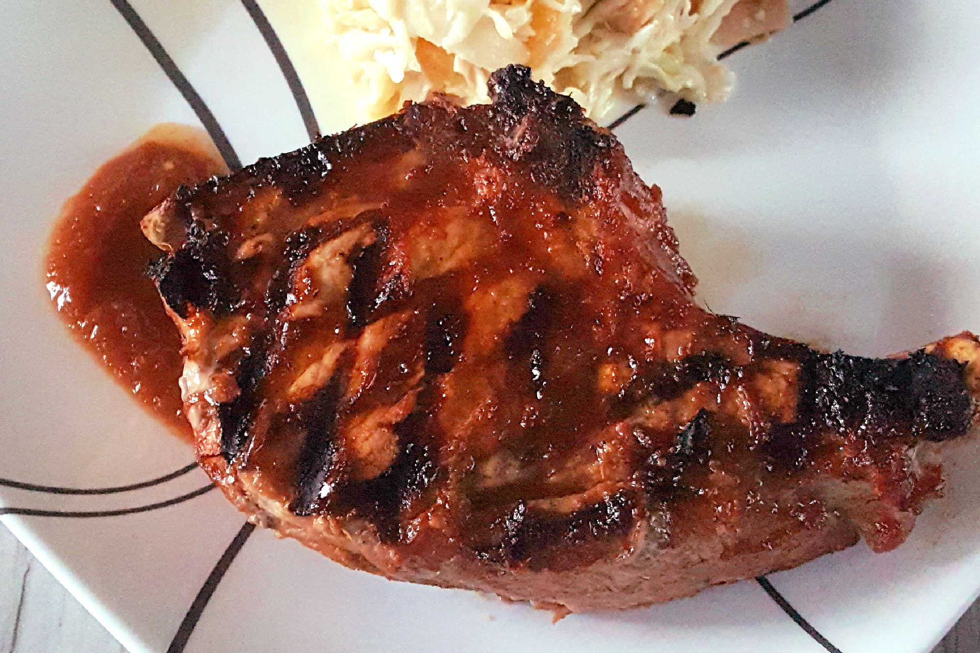 Savor the sweet and smoky harmony of pineapple barbeque chops paired with creamy colada slaw made with coconut chips and macadamia nuts. This dish brings people together and turns any meal into a mini celebration. #bbq #porkchop #pineapplesauce #pineapplebarbecue #PineappleBarbequeChops #ColadaSlaw #BBQlovers #SummerGrilling #TropicalFlavors