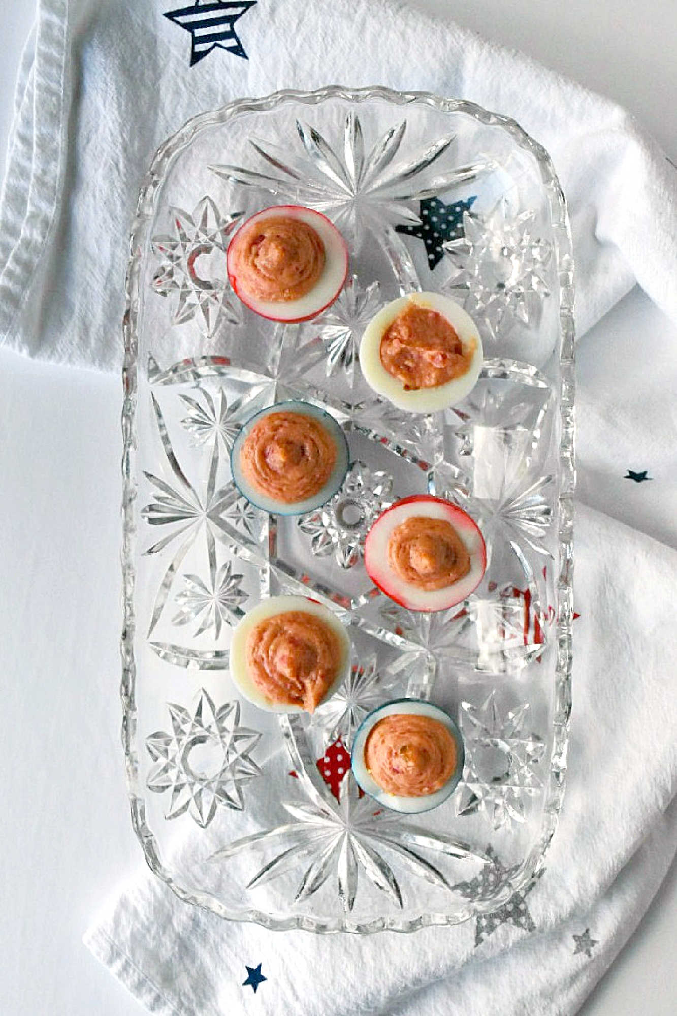 Wow the crowd with Red White & Blue Deviled Eggs, featuring a uniquely tangy roasted beet filling that sets these apart from the rest. Perfect for any patriotic celebration or family event. #deviledeggs #coloredeggs #patrioticfood #RWBDeviledEggs #PatrioticEats #SummerBBQRecipes #FourthofJulyFoods #FoodieFaves #FourthOfJulyFoodies #DeviledEggHeaven #AmericanTable #USAFeast