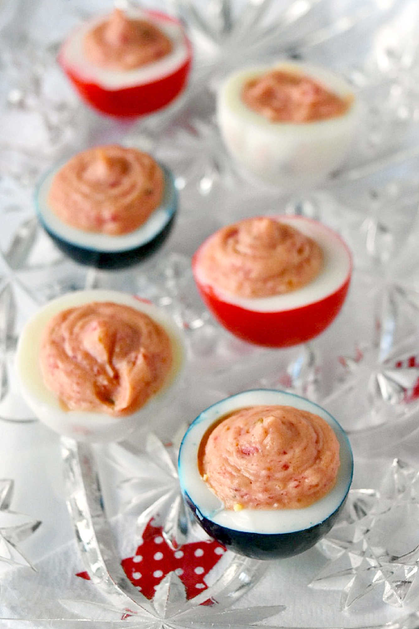 Wow the crowd with Red White & Blue Deviled Eggs, featuring a uniquely tangy roasted beet filling that sets these apart from the rest. Perfect for any patriotic celebration or family event. #deviledeggs #coloredeggs #patrioticfood #RWBDeviledEggs #PatrioticEats #SummerBBQRecipes #FourthofJulyFoods #FoodieFaves #FourthOfJulyFoodies #DeviledEggHeaven #AmericanTable #USAFeast