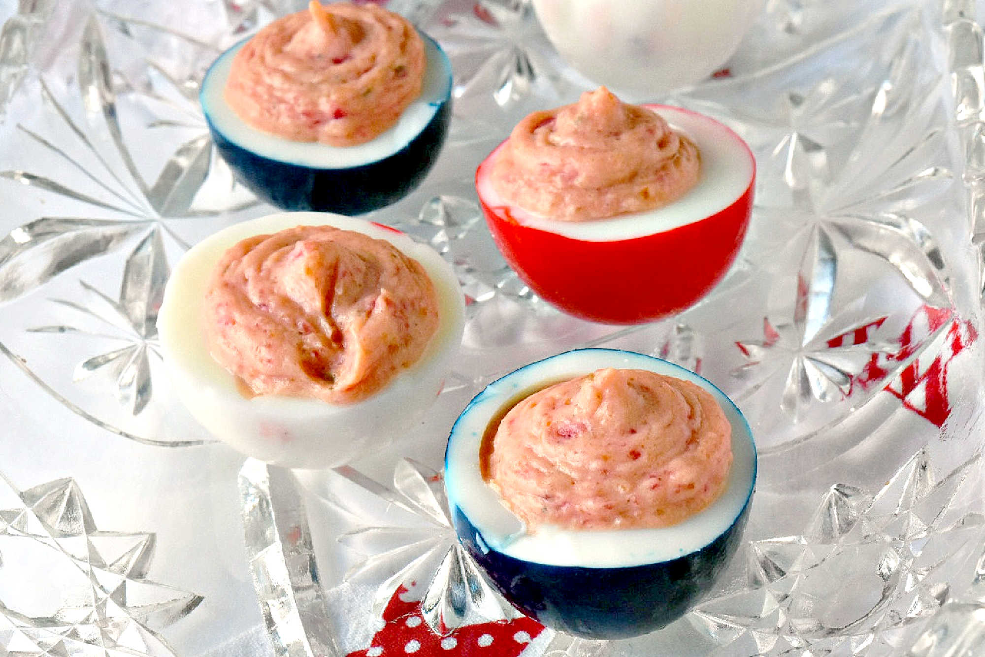 Wow the crowd with Red White & Blue Deviled Eggs, featuring a uniquely tangy roasted beet filling that sets these apart from the rest. Perfect for any patriotic celebration or family event. #deviledeggs #coloredeggs #patrioticfood #RWBDeviledEggs #PatrioticEats #SummerBBQRecipes #FourthofJulyFoods #FoodieFaves #FourthOfJulyFoodies #DeviledEggHeaven #AmericanTable #USAFeast