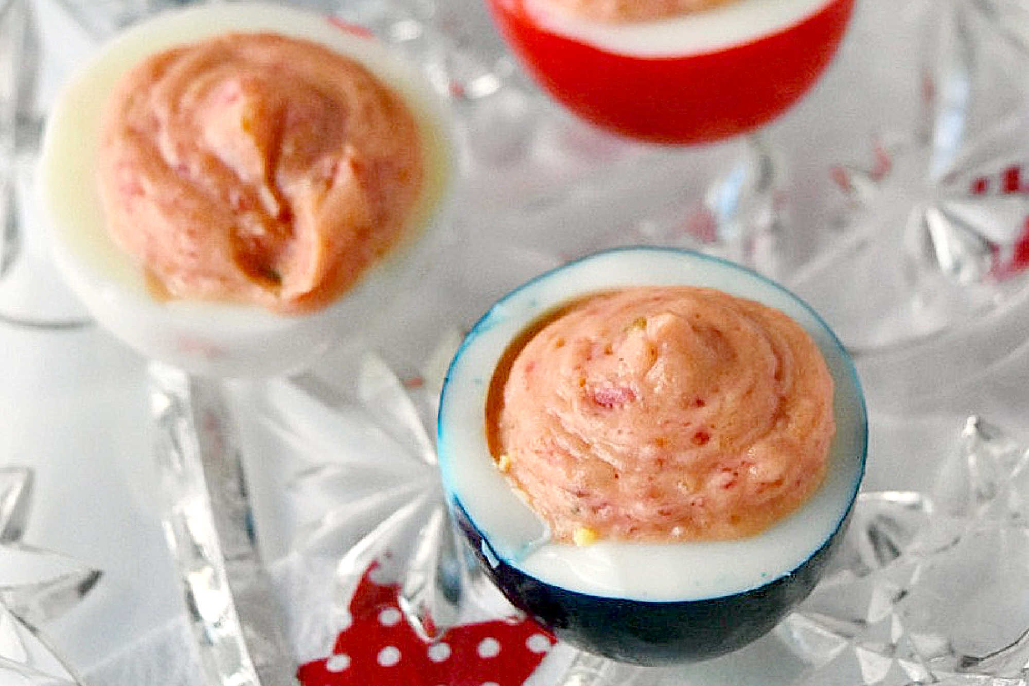 Wow the crowd with Red White & Blue Deviled Eggs, featuring a uniquely tangy roasted beet filling that sets these apart from the rest. Perfect for any patriotic celebration or family event. #deviledeggs #coloredeggs #patrioticfood #RWBDeviledEggs #PatrioticEats #SummerBBQRecipes #FourthofJulyFoods #FoodieFaves #FourthOfJulyFoodies #DeviledEggHeaven #AmericanTable #USAFeast