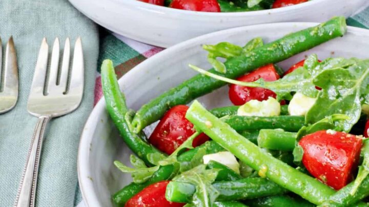 The recipe for this green bean salad with tomatoes, arugula, and basil dressing takes advantage of fresh ingredients that you can find at a farmers' market or your own garden.