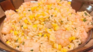 Creamy Risotto, Fresh Sweet Corn, Shaved Parmesan Cheese, and Garlic Sauteed Shrimp combine to make an elegant, beautiful dinner.