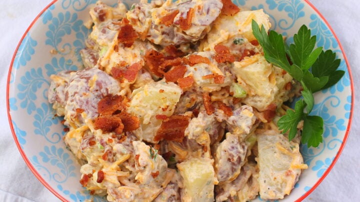 Fully loaded potato salad with bacon, cheddar, sour cream, and chives is a perfect side for sandwiches and casual suppers.