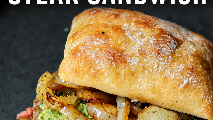 Make this easy Blackstone Griddle Steak Sandwich with juicy ribeye, grilled onions, homemade basil pesto, and steak sauce on toasted bread.