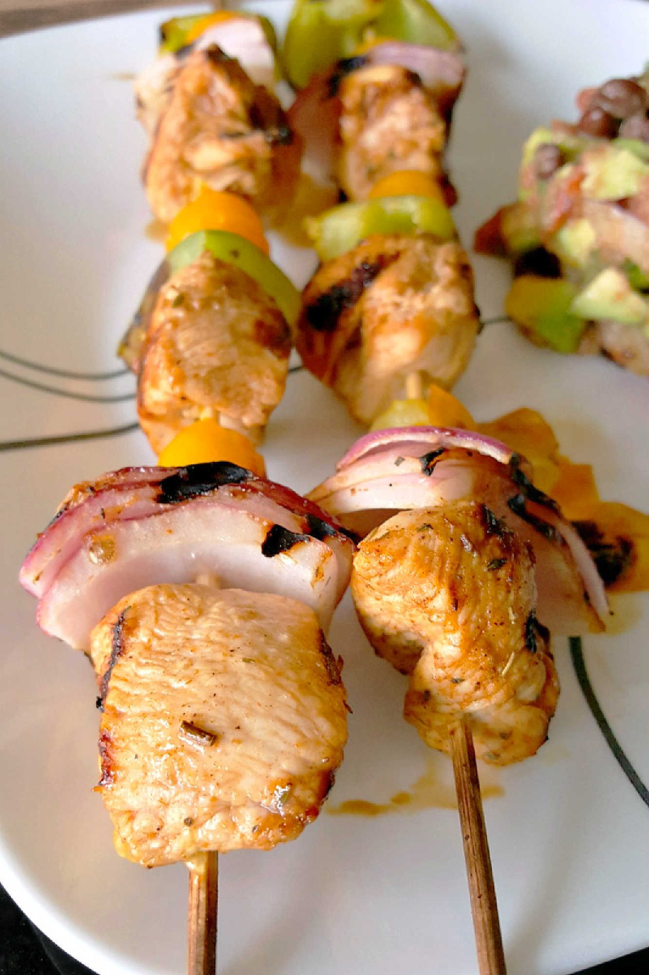 Fire up the grill for Chicken Fajita Kabobs loaded with juicy chicken, sweet peppers, onions, and bursty cherry tomatoes. Serve the smoky skewers with black bean and avocado salsa for a fresh, creamy, colorful Tex-Mex dinner that’s cookout ready and family approved. #ChickenFajitaKabobs #EasyGrillingRecipes #SummerDinner #ChickenKabobs #TexMexRecipes #AvocadoSalsa #FamilyMeals #OurFamilyTable