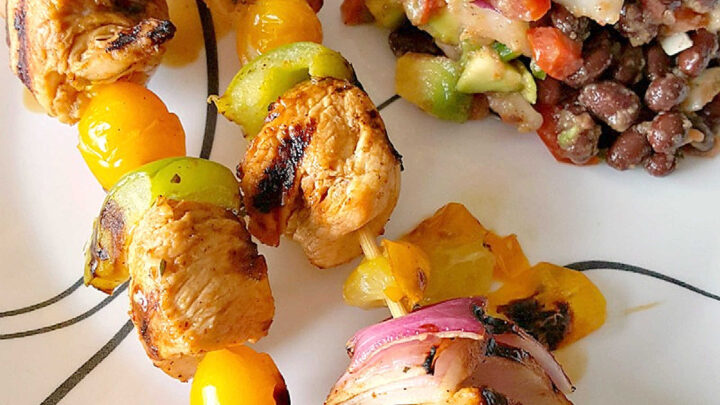 Fire up the grill for Chicken Fajita Kabobs loaded with juicy chicken, sweet peppers, onions, and bursty cherry tomatoes. Serve the smoky skewers with black bean and avocado salsa for a fresh, creamy, colorful Tex-Mex dinner that’s cookout ready and family approved. #ChickenFajitaKabobs #EasyGrillingRecipes #SummerDinner #ChickenKabobs #TexMexRecipes #AvocadoSalsa #FamilyMeals #OurFamilyTable