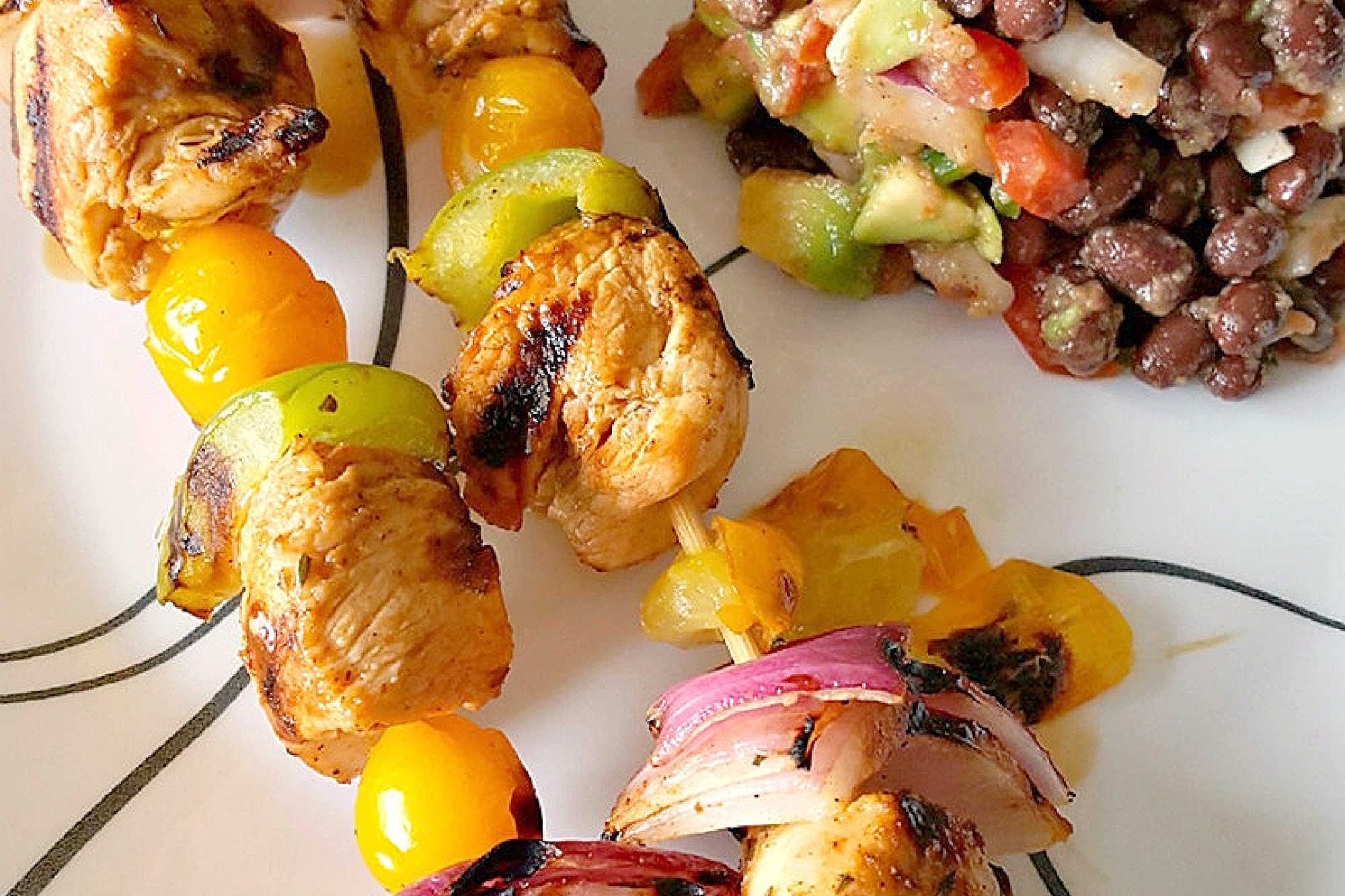Fire up the grill for Chicken Fajita Kabobs loaded with juicy chicken, sweet peppers, onions, and bursty cherry tomatoes. Serve the smoky skewers with black bean and avocado salsa for a fresh, creamy, colorful Tex-Mex dinner that’s cookout ready and family approved. #ChickenFajitaKabobs #EasyGrillingRecipes #SummerDinner #ChickenKabobs #TexMexRecipes #AvocadoSalsa #FamilyMeals #OurFamilyTable