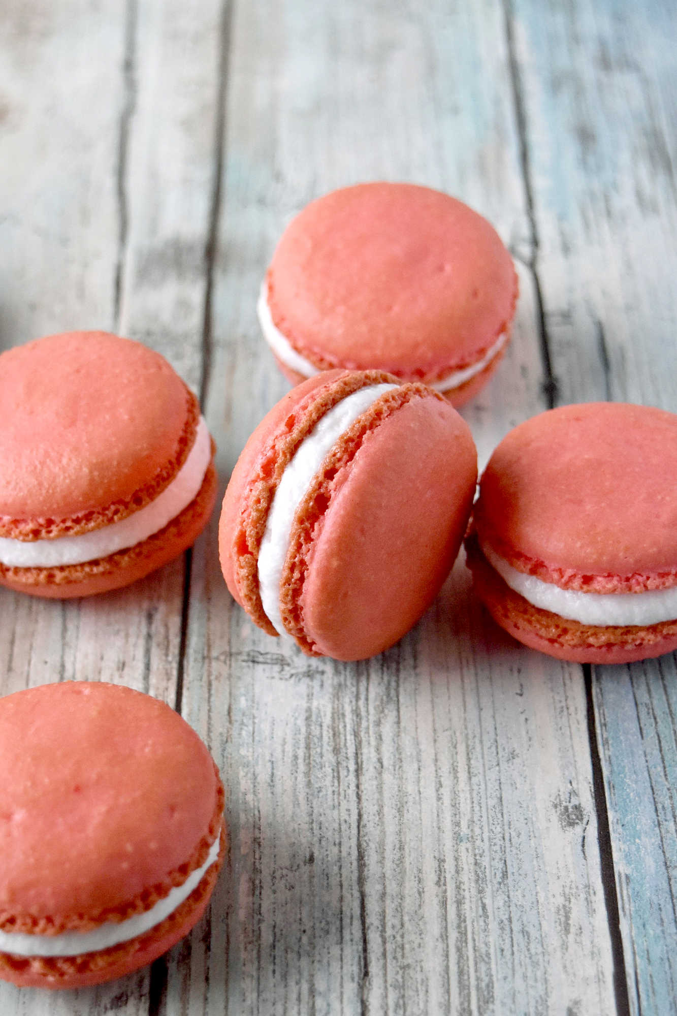 Peach macarons are the sweetest little summer bake. These use freeze-dried peaches in the shells and peach syrup in the filling for bright, fruity flavor in every bite. Perfect for a beginner-friendly showstopper! #peachmacarons #macarons #frenchmacarons #macaronlove #peachdessert #summerdesserts #prettybakes #bakingfromscratch #homebaker #desserttable #teapartyideas #bridalshowerdesserts #Stonefruit