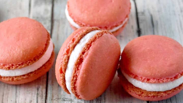Peach macarons are the sweetest little summer bake. These use freeze-dried peaches in the shells and peach syrup in the filling for bright, fruity flavor in every bite. Perfect for a beginner-friendly showstopper! #peachmacarons #macarons #frenchmacarons #macaronlove #peachdessert #summerdesserts #prettybakes #bakingfromscratch #homebaker #desserttable #teapartyideas #bridalshowerdesserts #Stonefruit